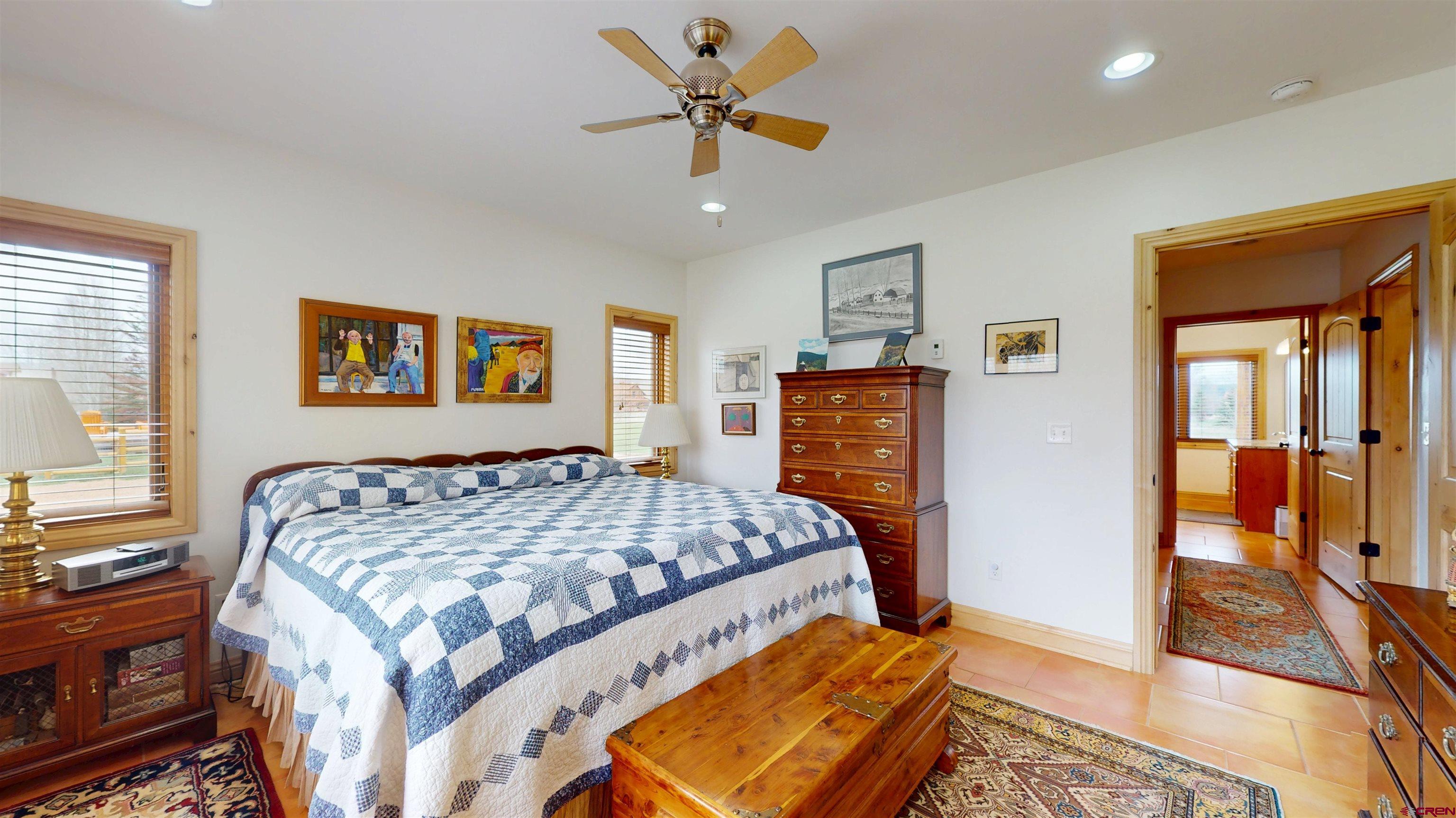 157 Spring Meadow Trail Gunnison, CO 81230 - Photo 34 of 43 a bedroom with a large bed and a chandelier