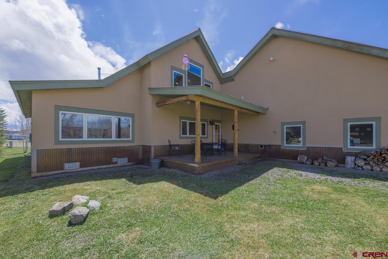 157 Spring Meadow Trail Gunnison, CO 81230 - Photo 5 of 43 a front view of a house with a yard fire pit and outdoor seating
