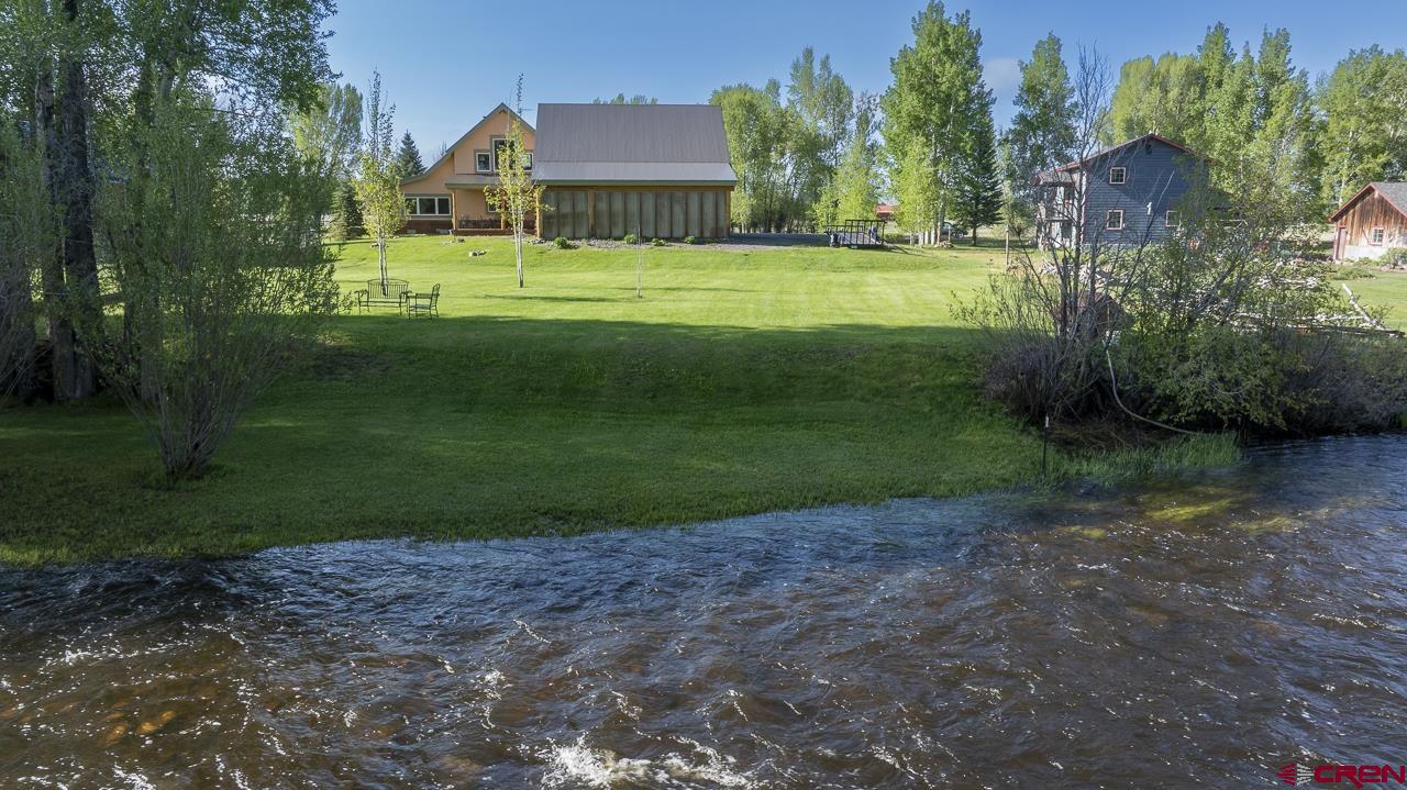 157 Spring Meadow Trail Gunnison, CO 81230 - Photo 6 of 43 a view of a house with a big yard and a large trees