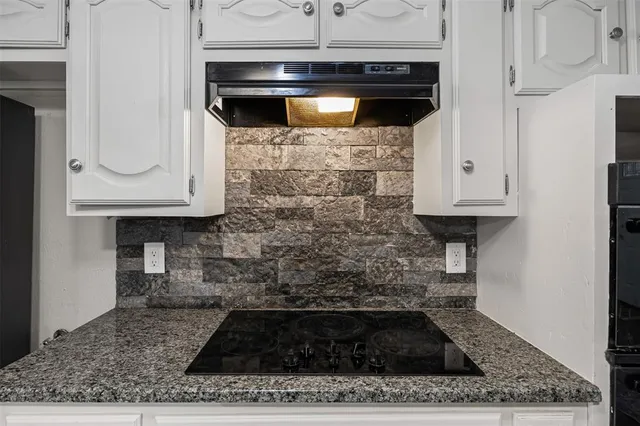 a kitchen with white cabinets and a stove