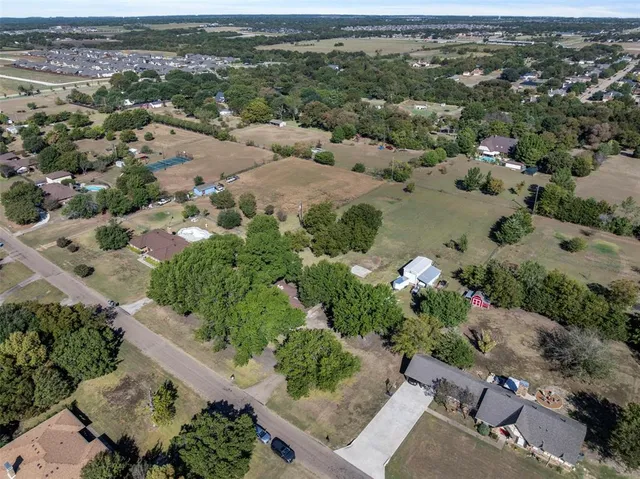 an aerial view of a houses with a yard
