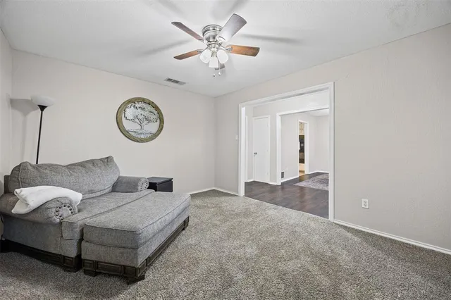 a living room with furniture a clock and a ceiling fan