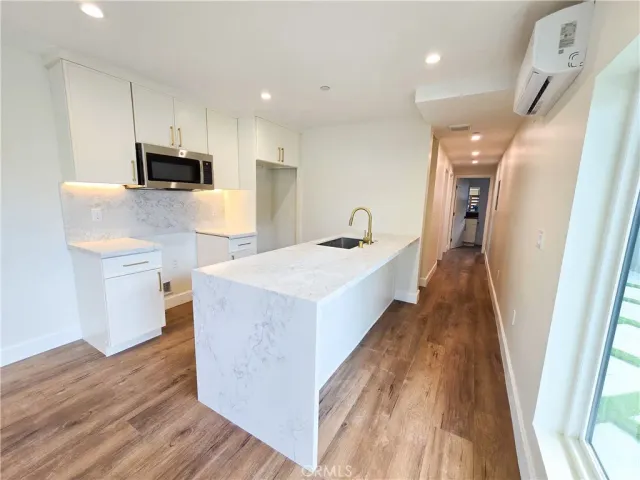 a view of kitchen with sink microwave and refrigerator
