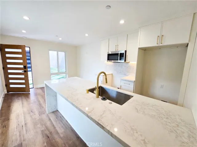 a kitchen with stainless steel appliances a sink a stove a refrigerator and cabinets
