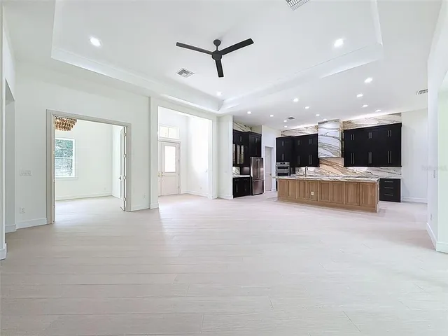 en empty room with windows and ceiling fan