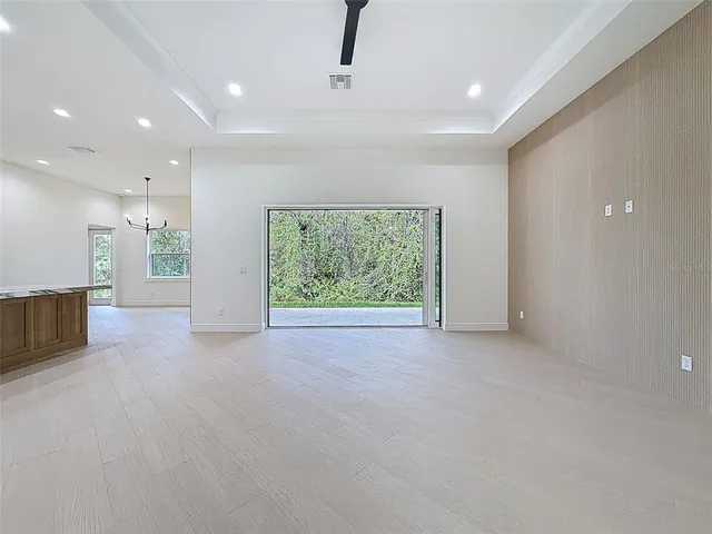 an empty room with a ceiling fan and window