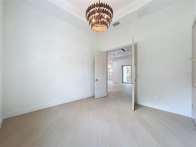 an empty room with a ceiling fan and carpet