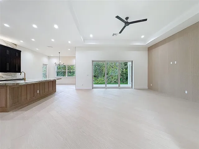a large kitchen with stainless steel appliances a sink and cabinets