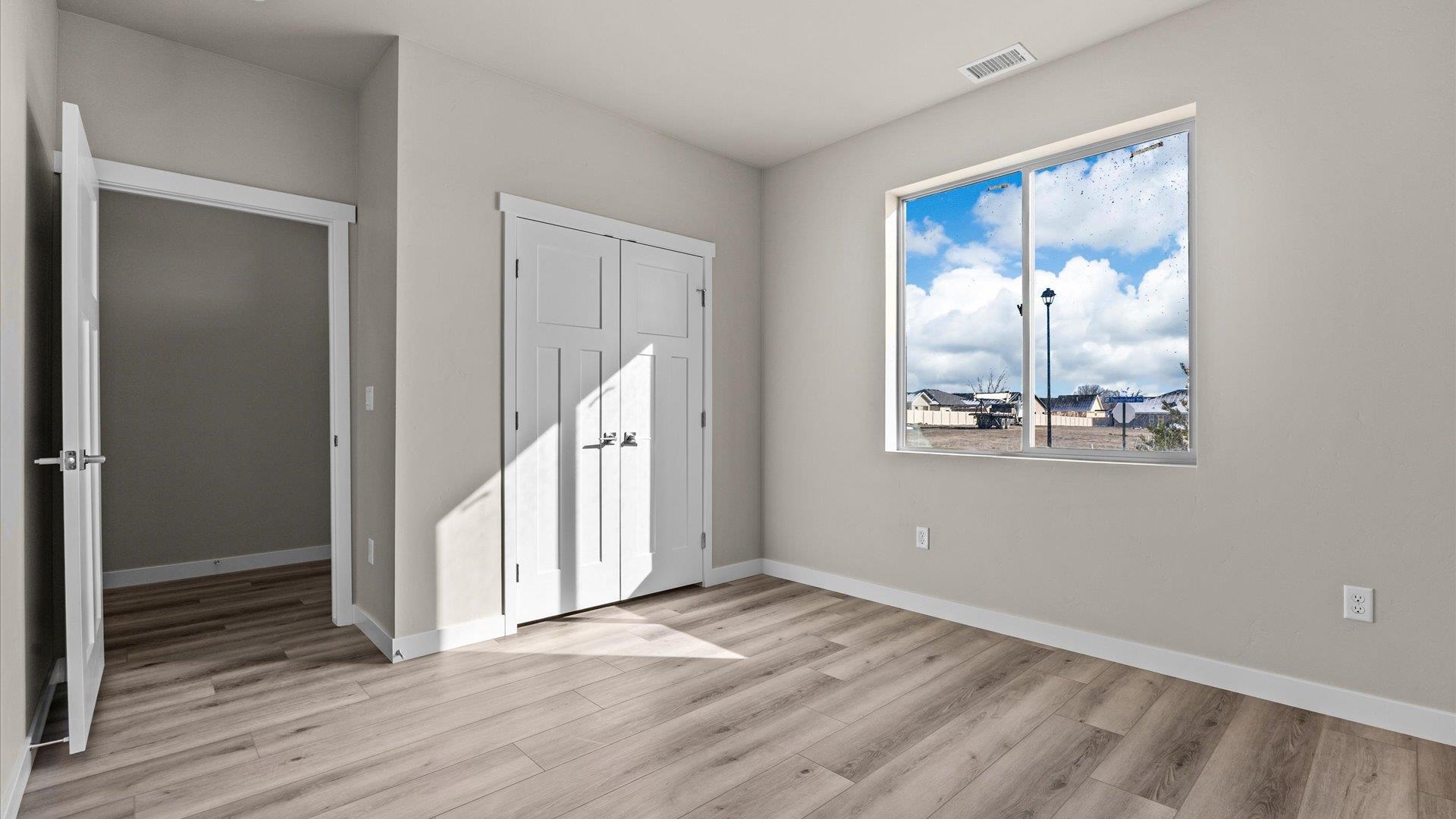 3066 Thunderhead Way Grand Junction, CO 81504 - Photo 23 of 30 an empty room with wooden floor mirror and windows