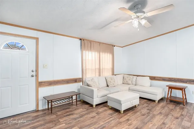 a living room with furniture and a wooden floor