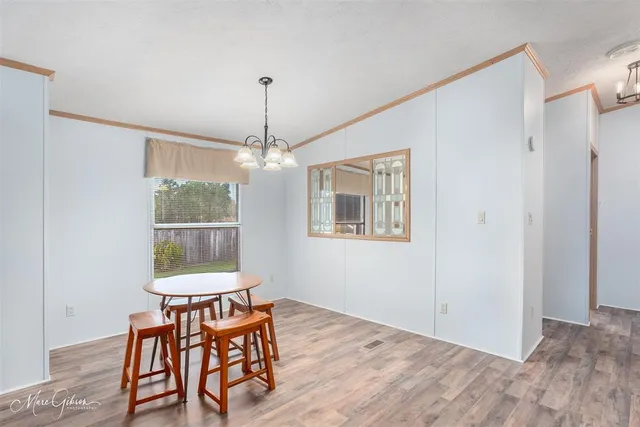 a dining room with furniture a chandelier and wooden floor