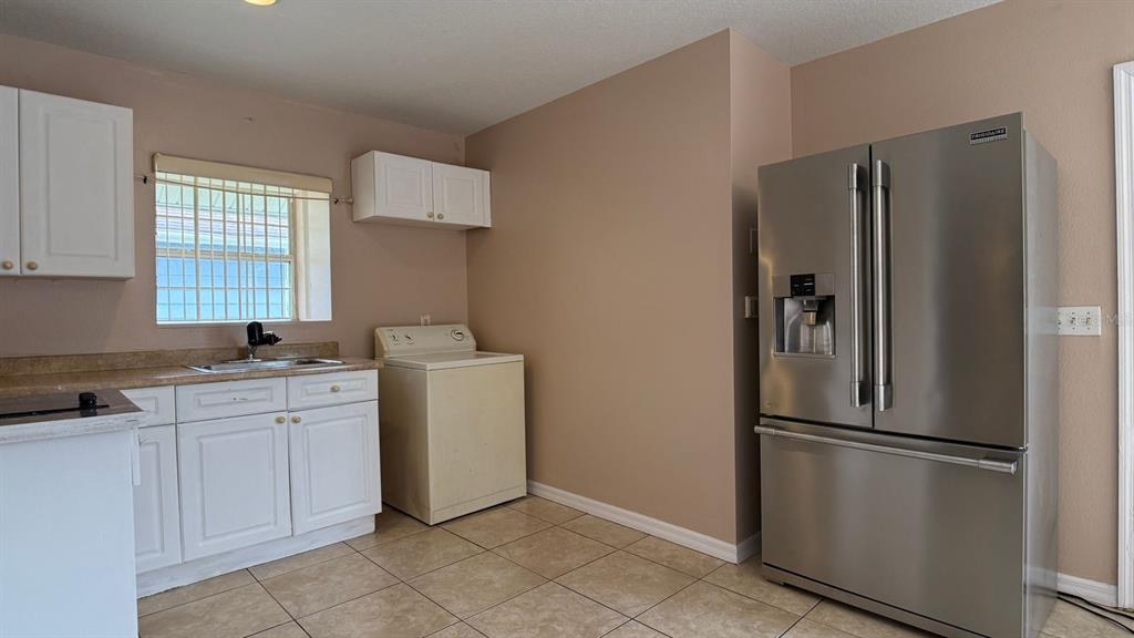211 Caribbean Drive, Unit LOCKOUT Davenport, FL 33897 - Photo 4 of 14 a kitchen with a refrigerator sink and cabinets