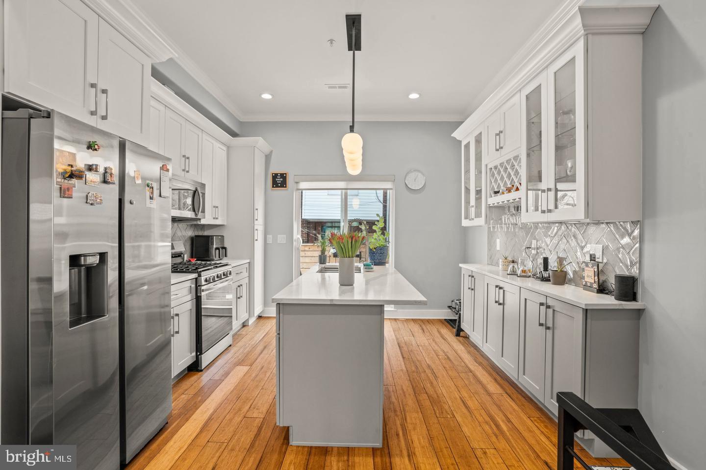 1751 South Taylor Street Philadelphia, PA 19145 - Photo 5 of 28 a kitchen with stainless steel appliances granite countertop a refrigerator a oven a stove and white cabinets with wooden floor