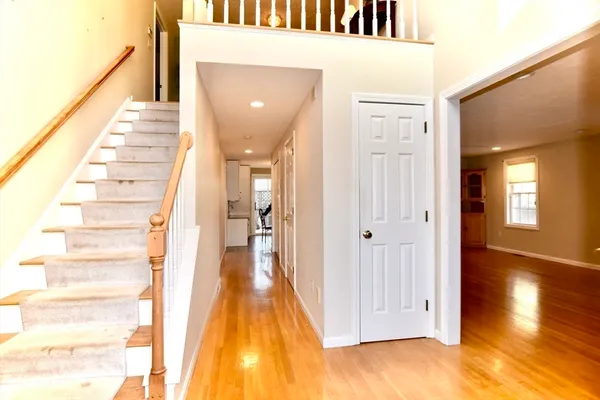 a view of a hallway with wooden floor and staircase