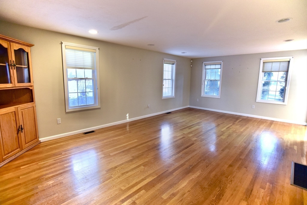 172 Edgehill Road, Unit 172 Norwood, MA 02062 - Photo 8 of 27 a view of an empty room with wooden floor and a window