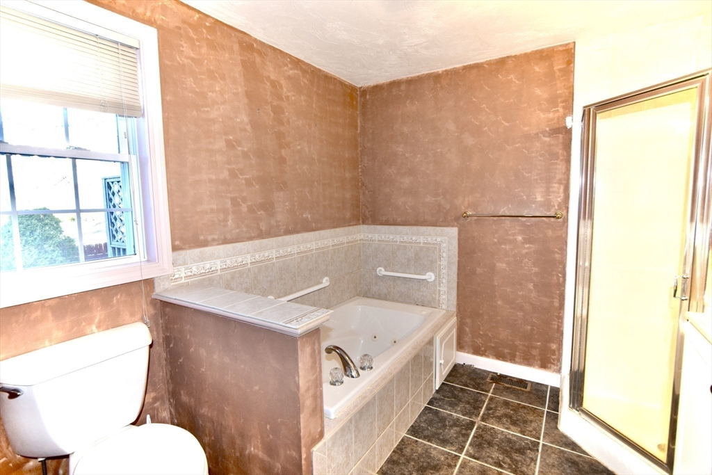 172 Edgehill Road, Unit 172 Norwood, MA 02062 - Photo 10 of 27 a bathroom with a granite countertop sink toilet and shower
