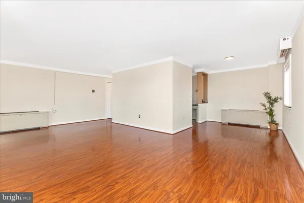 a view of empty room with wooden floor