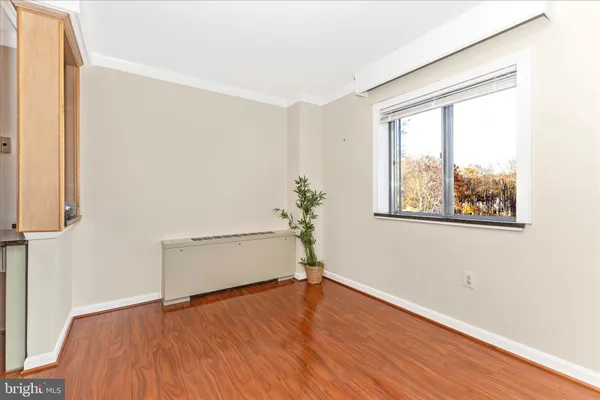 an empty room with wooden floor and window