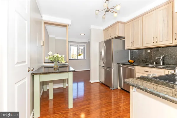 a kitchen with granite countertop a refrigerator and a stove top oven