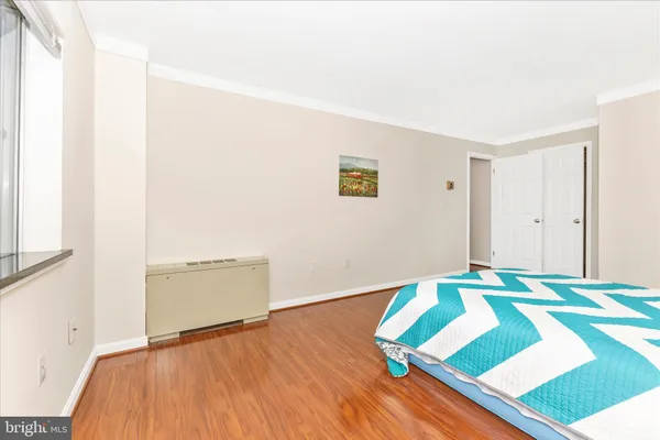 a bedroom with a bed and a painting on the wall