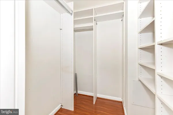 a view of walk in closet with wooden floor