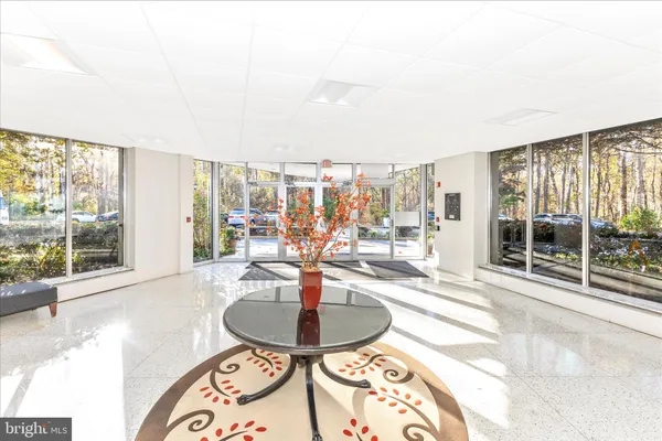 a dining room with furniture and large windows