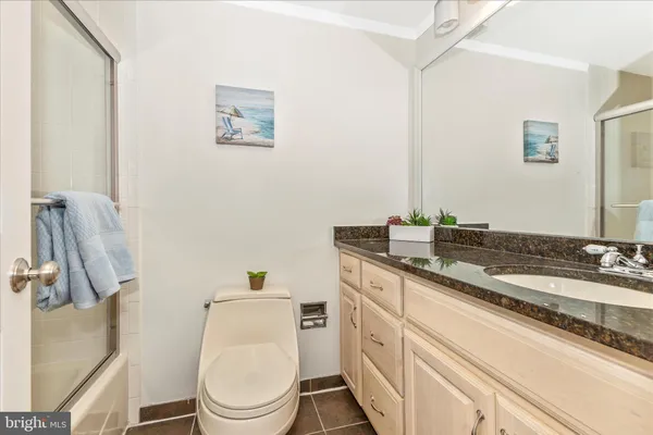 a bathroom with a granite countertop toilet sink and mirror