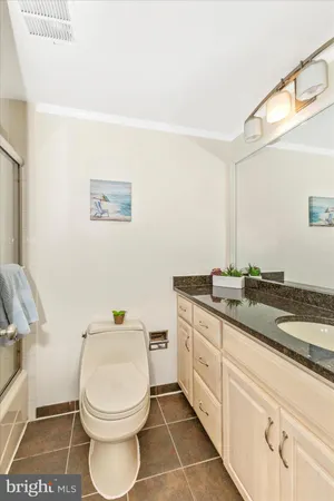 a bathroom with a granite countertop toilet a sink and a mirror