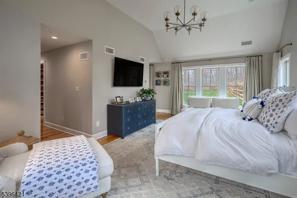 a bedroom with a bed television and a window