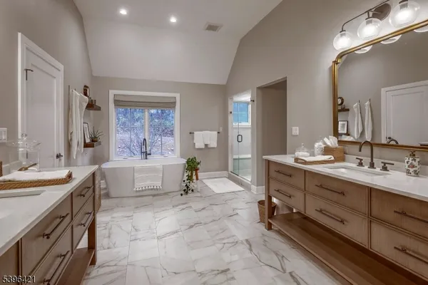 a spacious bathroom with a double vanity sink a mirror and a bathtub