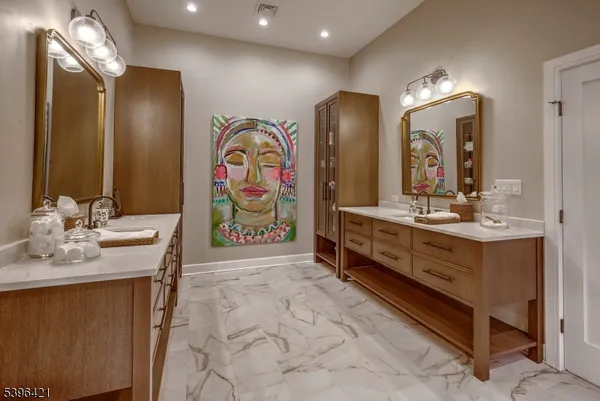 a bathroom with double vanity sinks a vanity a lamp and a mirror