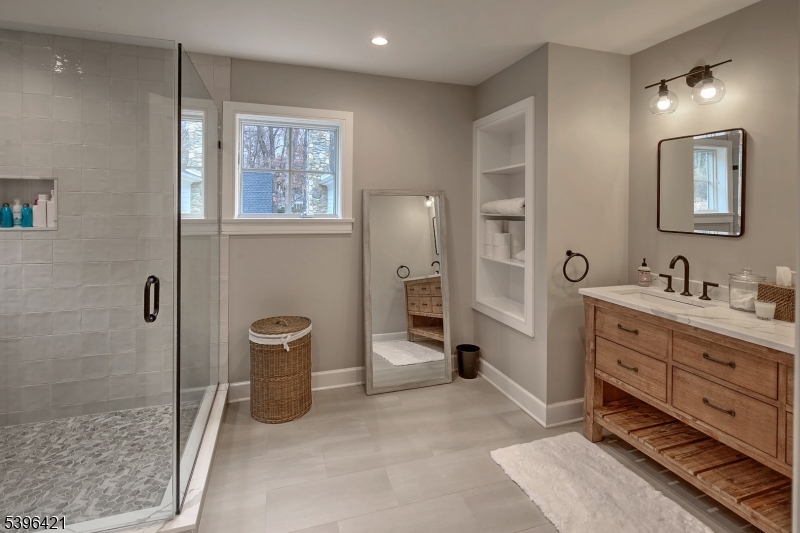 93 Pleasantville Road New Vernon, NJ 07976 - Photo 25 of 41 a spacious bathroom with a double vanity sink a mirror and a shower