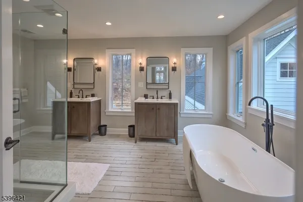 a bathroom with a bathtub and double vanity