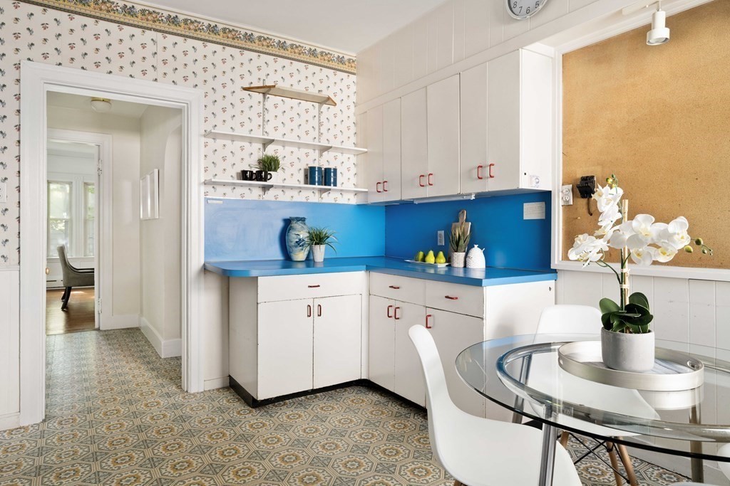 215 Clark Road Brookline, MA 02445 - Photo 11 of 41 a kitchen with stainless steel appliances white cabinets a table and chairs