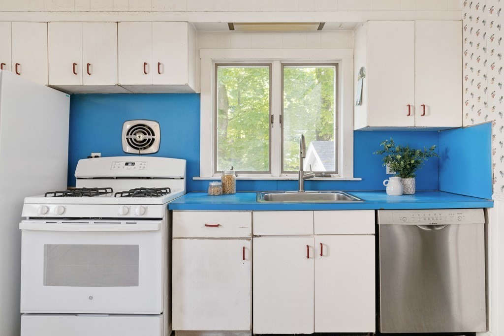 215 Clark Road Brookline, MA 02445 - Photo 10 of 41 a kitchen with stainless steel appliances granite countertop a sink a stove and white cabinets
