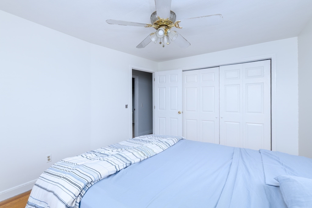 29 Manor Road Auburn, MA 01501 - Photo 16 of 21 a bedroom with a bed and a chandelier fan