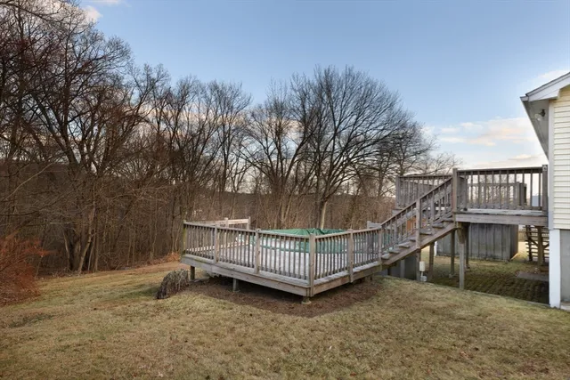 a view of a house with a wooden deck and a backyard