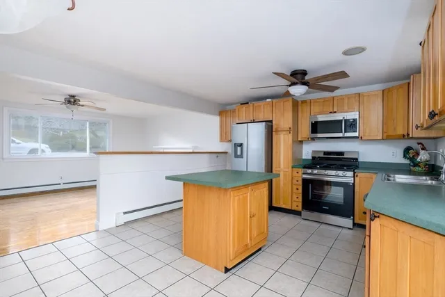 a kitchen with stainless steel appliances granite countertop a refrigerator a stove and a sink