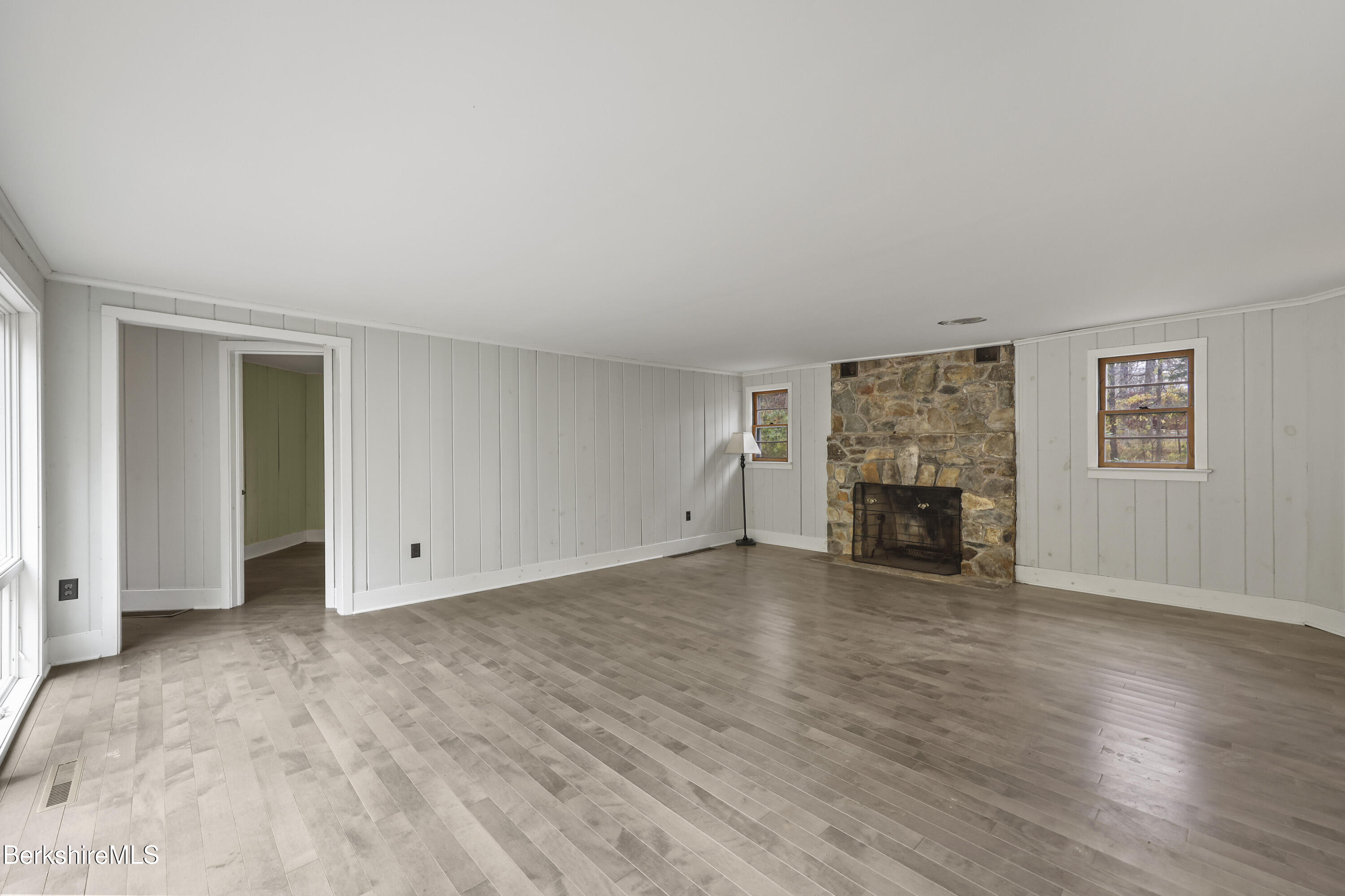 245 Long Pond Road Great Barrington, MA 01230 - Photo 7 of 34 a view of an empty room with wooden floor and a fireplace