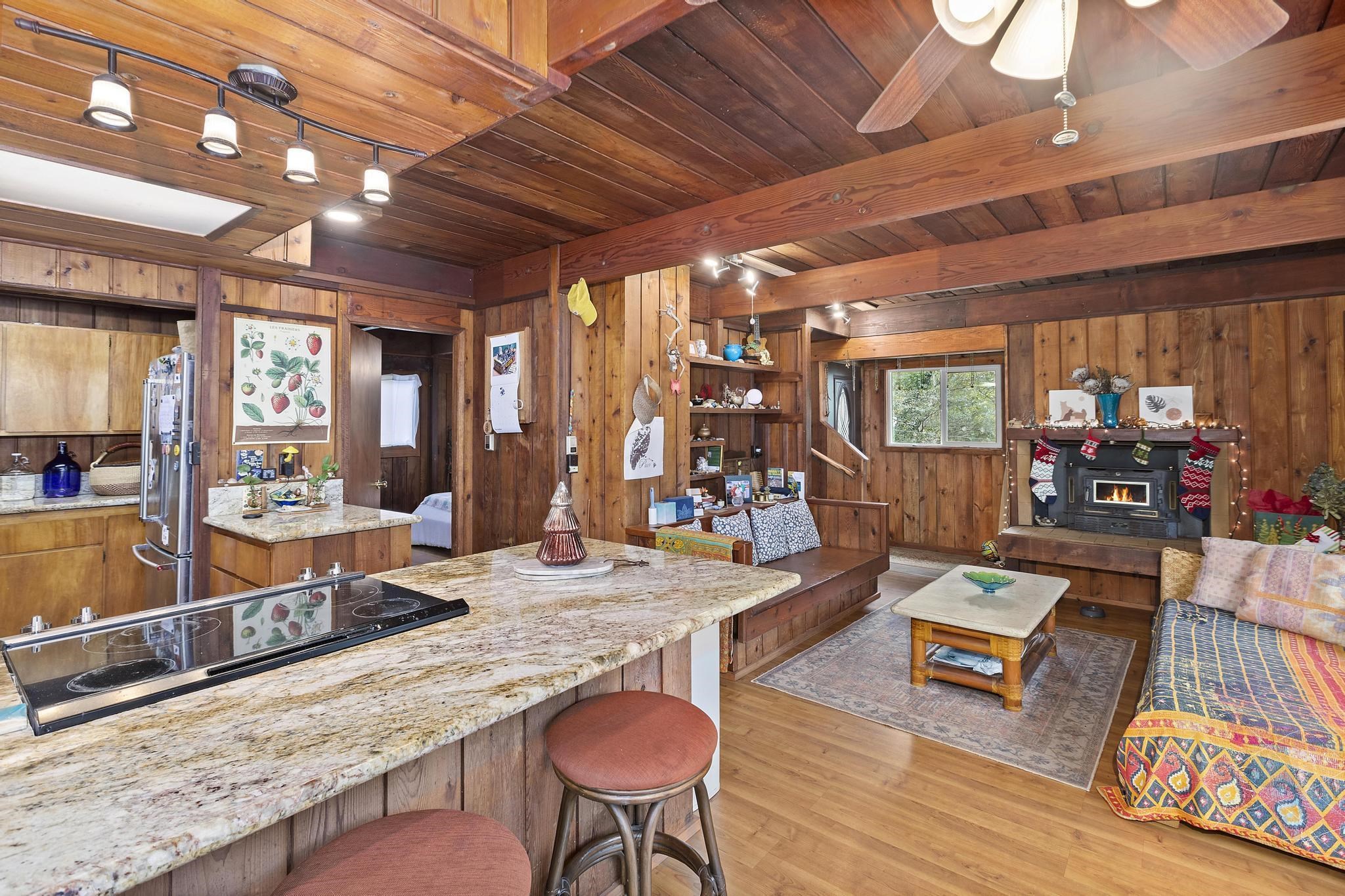 2450 Piiholo Road Makawao, HI 96768 - Photo 33 of 39 a living room with furniture a rug kitchen view and a large window