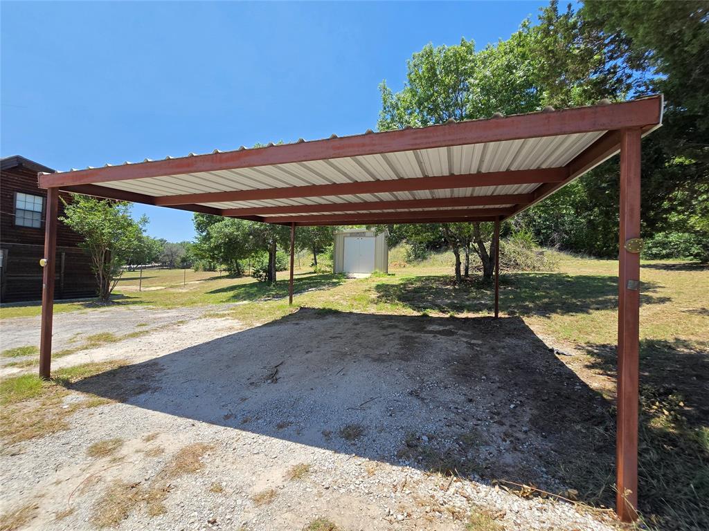 3505 Farmer Road Azle, TX 76020 - Photo 38 of 40 Two-car carport provides covered parking. Well house has room for additional storage solutions for yard equipment, plus a water softener is already installed!