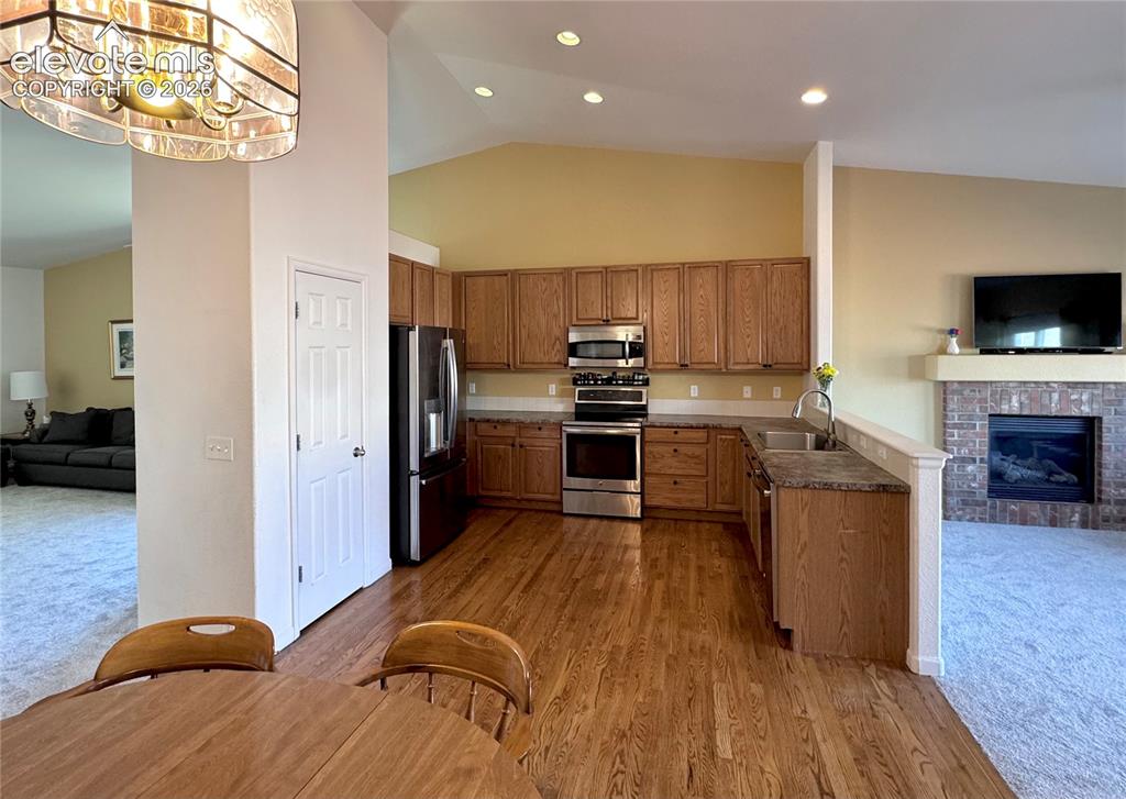 9362 St.George Road Peyton, CO 80831 - Photo 7 of 32 a kitchen with a refrigerator a stove top oven a sink dishwasher and wooden cabinets