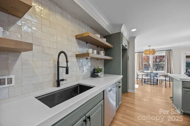 a kitchen with stainless steel appliances a sink a stove and a refrigerator with wooden floor