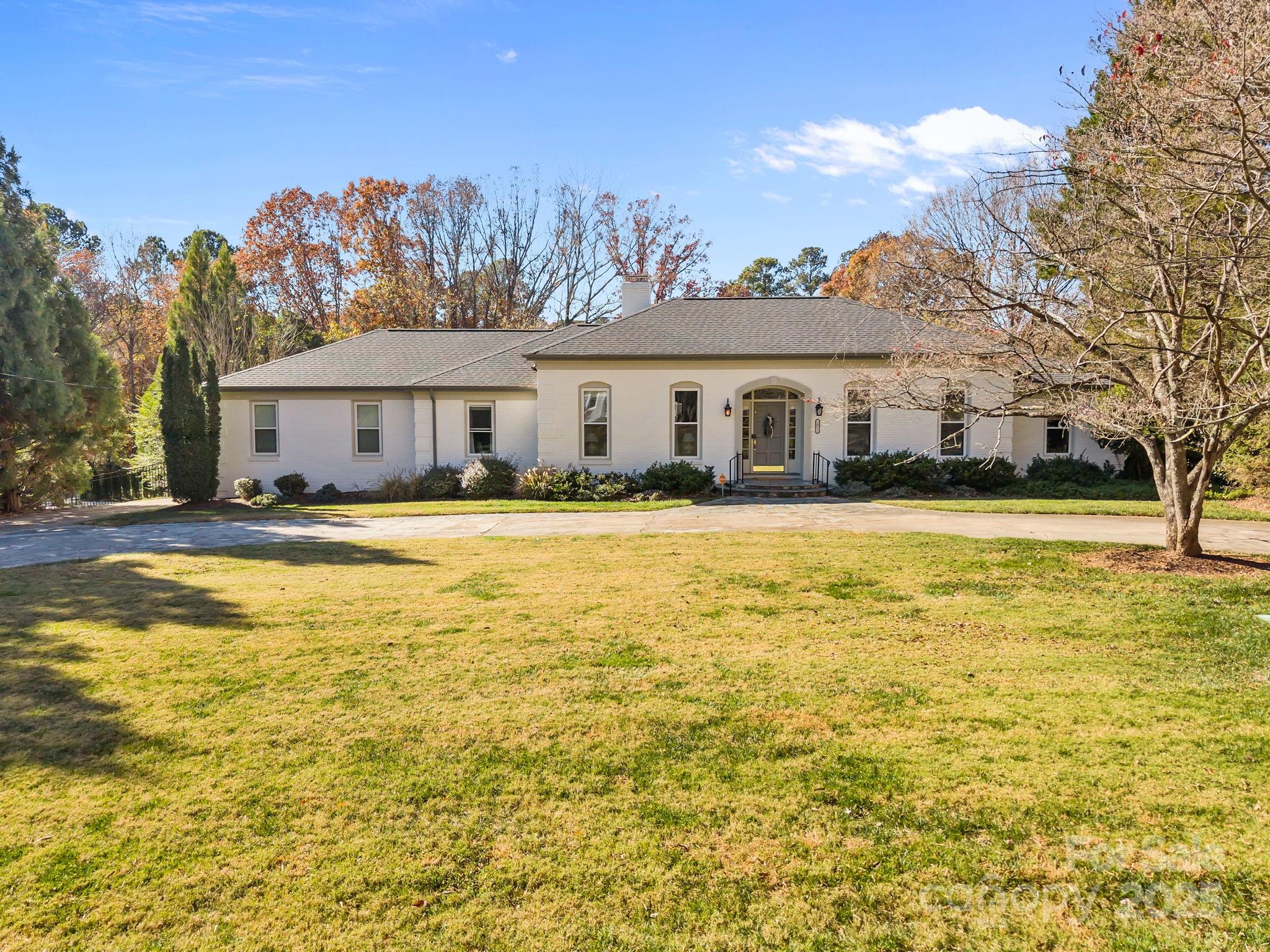 1022 Churchill Road Davidson, NC 28036 - Photo 2 of 39 a view of house with swimming pool and trees in the background