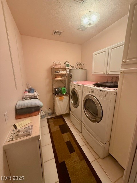 10561 Rancho Destino Road Las Vegas, NV 89183 - Photo 19 of 29 Laundry area featuring washer and clothes dryer, a textured ceiling, visible vents, cabinet space, and light tile patterned floors