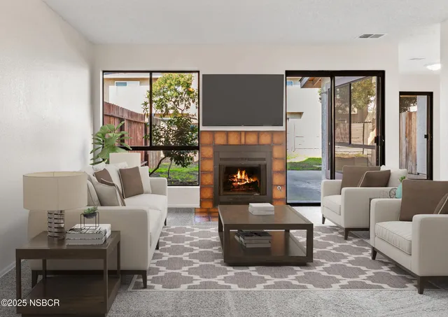 a living room with furniture a fireplace and a large window