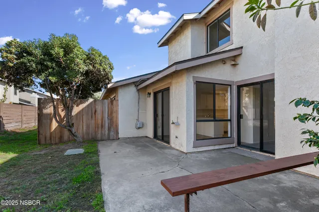 a view of a house with a yard and potted plants