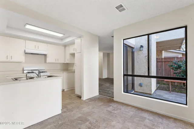 a kitchen with refrigerator cabinets and wooden floor