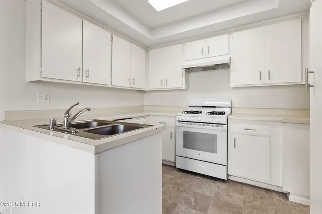 a kitchen with granite countertop white cabinets and white appliances