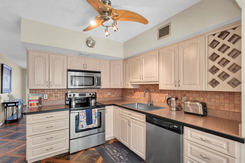 2469 Franciscan Drive, Unit 53 Clearwater, FL 33763 - Photo 11 of 51 a kitchen with stainless steel appliances granite countertop a sink a stove and cabinets